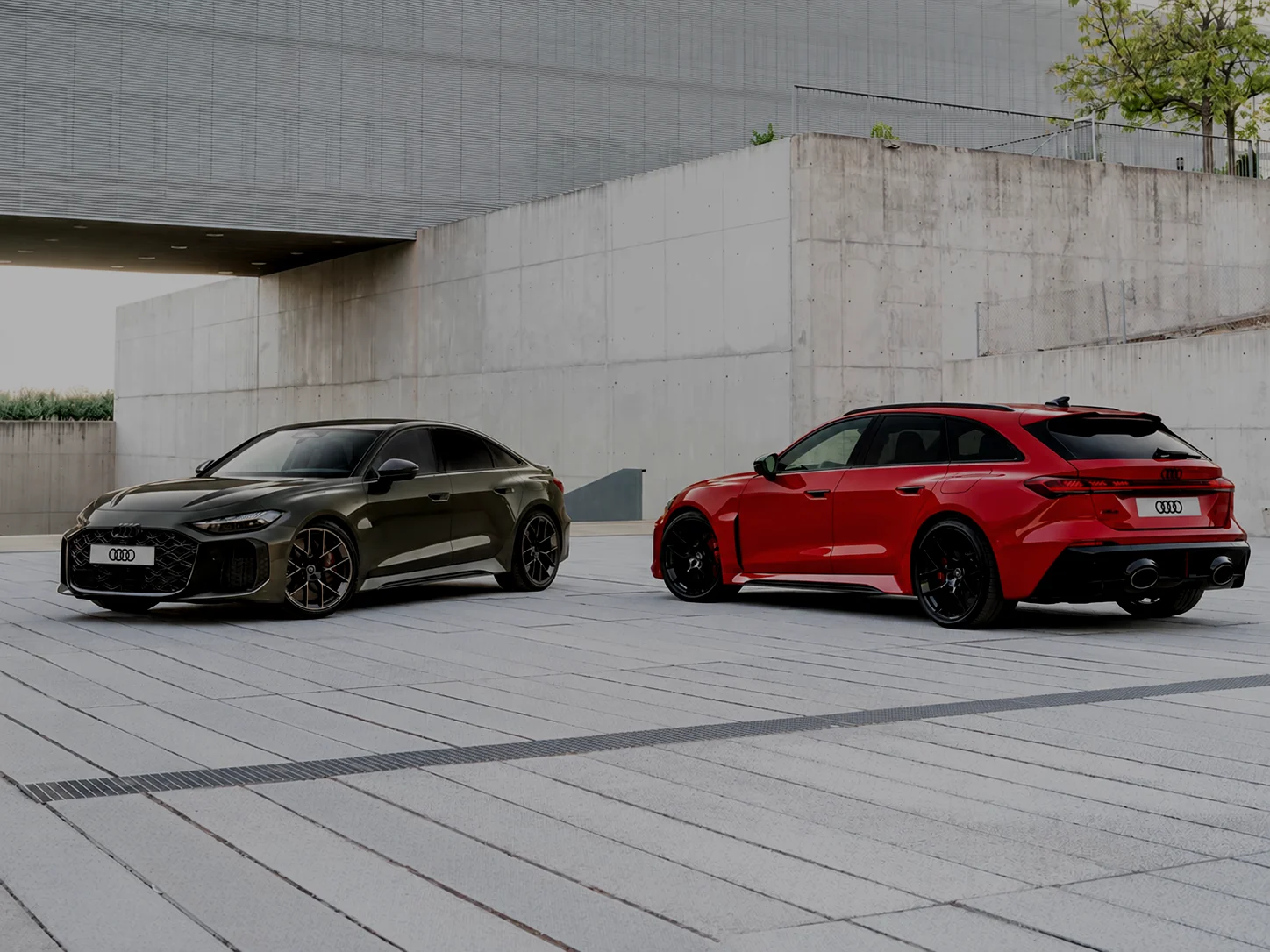 Two performance estate and saloon models on a concrete plaza